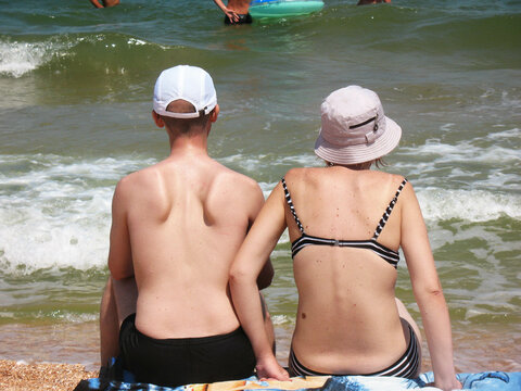 oung couple sitting on the seashore
