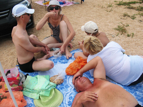 the family sits on the seashore
