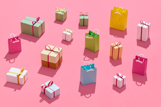 little gift boxes and shopping bags on pink background
