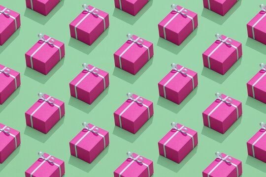 Pink gifts with ribbon on green background.