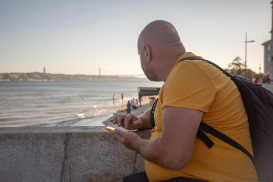 man with phone sitting on the embankment