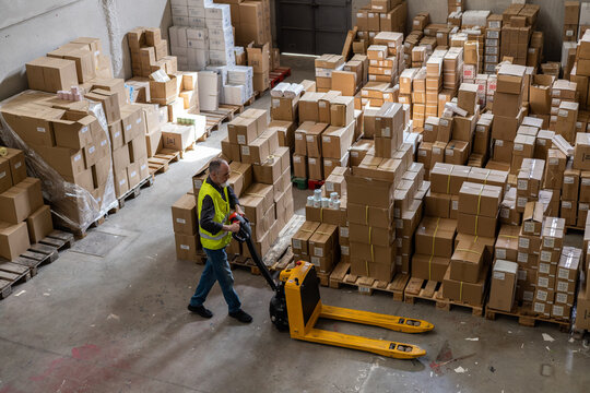 A worker using machinery in a warehouse.