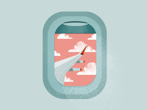 Airplane wing seen through window during sunset