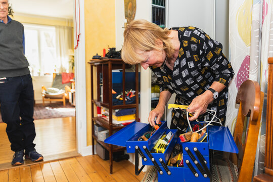 Senior woman looking in toolbox for correct equipment