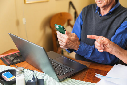 Senior citizen sitting at home paying family bills together