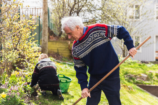 Senior couple cutting weeds and cleaning up at garden