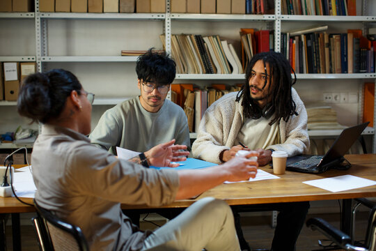 Startup Coworkers discussing business plan in their messy office 