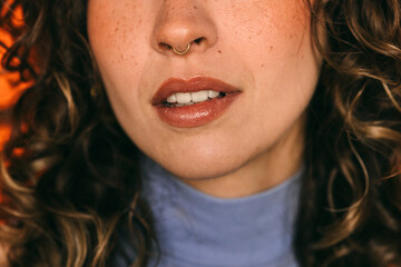 Close-up shot of a woman's lips and nose with curly hair