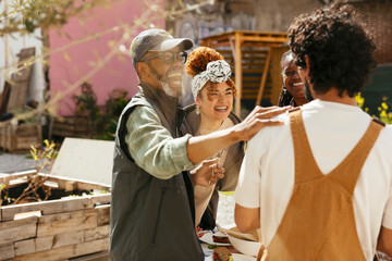 Diverse friends having lunch in community garden