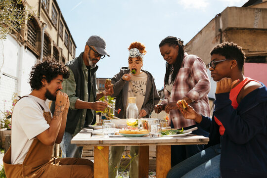 Diverse friends having lunch in community garden