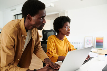 Two focused colleagues analyzing data