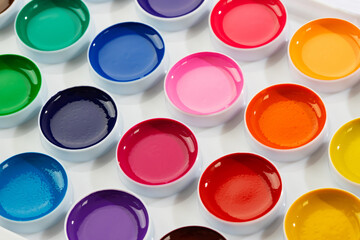 a set of watercolor paints in round bags in a white case
