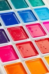 a set of watercolor paints in round bags in a white case
