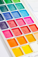 a set of watercolor paints in round bags in a white case
