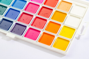 a set of watercolor paints in round bags in a white case
