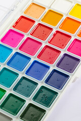 a set of watercolor paints in round bags in a white case
