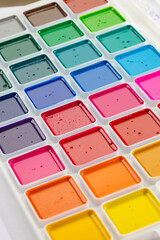 a set of watercolor paints in round bags in a white case
