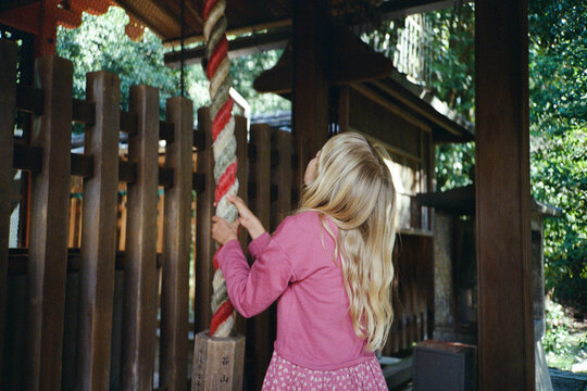 A girl ringing a Japanese shinto bell