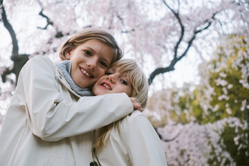 Two girls outdoors with cherry blossom