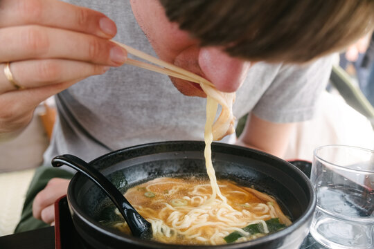 A man is eating noodles soup