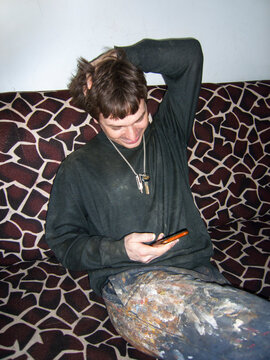 paint-stained worker uses smartphone