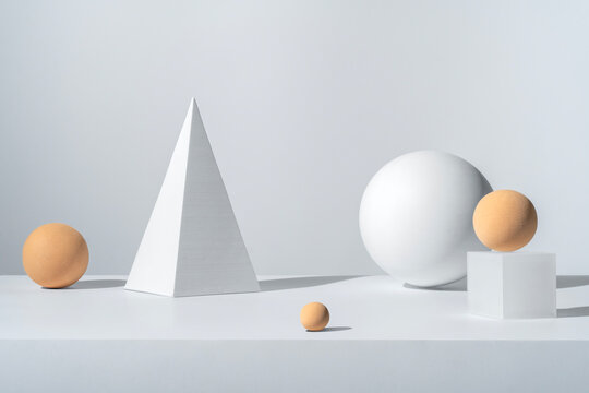 White cone and various spheres on white backdrop. Geometric stil life