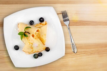 Crepes, pancakes with sauce and fresh berries