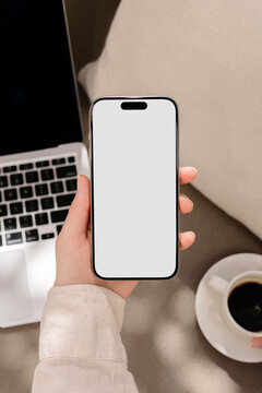 Mockup a phone with a white screen in female hands
