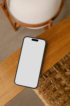 Mockup phone with white screen on Wooden Chair