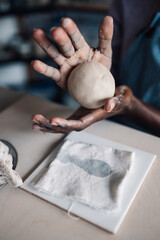 Close up of interracial course attendee learning pottery on course.