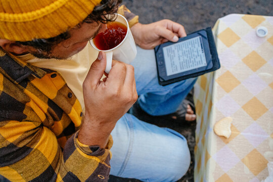 Man Reading E-Book at Outdoor Table