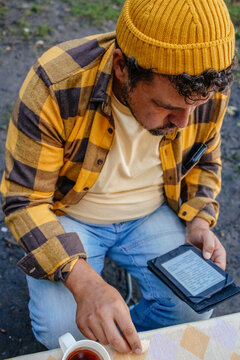 Man Reading E-Book at Outdoor Table