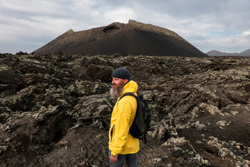 bearded man hiking on a volcano