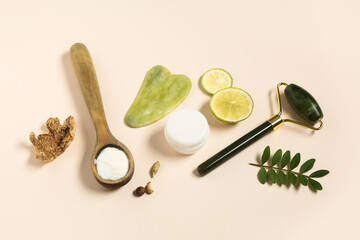 Face massage roller, guasha and natural ingredients for cosmetic mask on light background