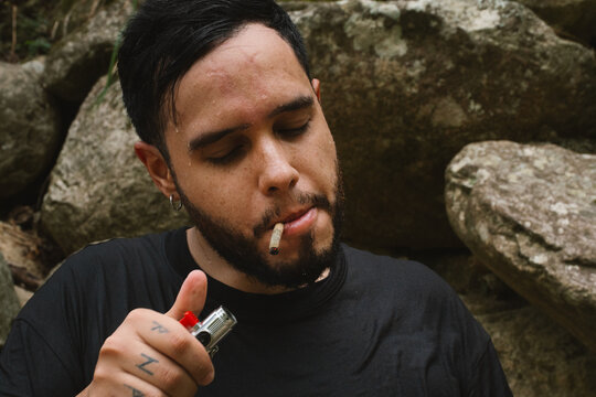 Young man smoking marijuana joint