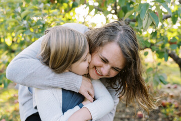 laughing mother and daughter outdoors together