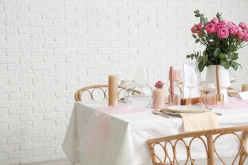 Beautiful table setting with pink roses and candles for wedding celebration in room
