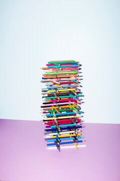  Tower made of colorful pencils iin office desh with hard flashlight
