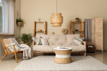 Interior of living room with comfortable sofa, coffee table, armchair and lamp