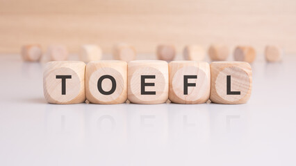 wooden cubes with letters form the expression TOEFL. education concept