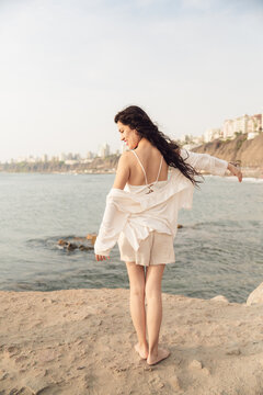 Woman Feeling The Wind on Rocky Beach