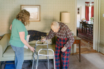 senior citizen with his daughter and caregiver in living room 