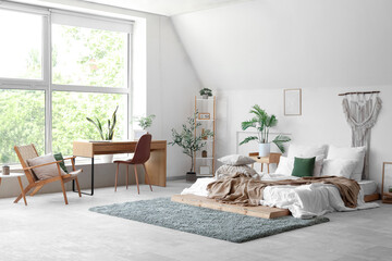 Cozy bed with soft pillows and crumpled blanket in interior of light bedroom