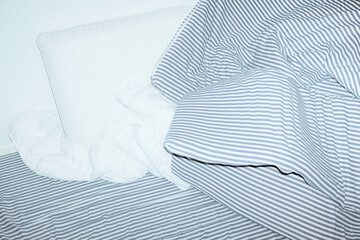 Bed with striped pattern duvet, mattress, pillow with hard flashlight