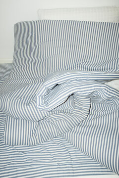 Bed with striped pattern duvet, mattress, pillow with hard flashlight
