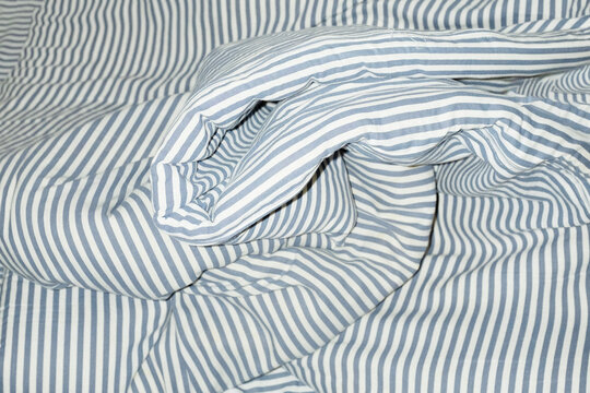Bed with striped pattern duvet, mattress, pillow with hard flashlight