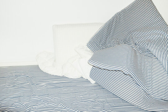 Bed with striped pattern duvet, mattress, pillow with hard flashlight