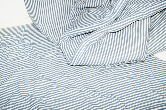 Bed with striped pattern duvet, mattress, pillow with hard flashlight