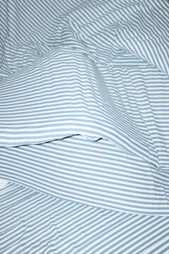 Bed with striped pattern duvet, mattress, pillow with hard flashlight