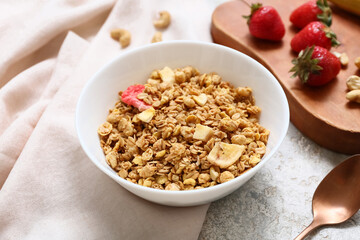 Tasty granola in bowl and napkin on grunge background, closeup